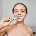 یک خانم در حال مسواک زدن - دکتر سعید بهکام دکتر سلامت در ونکوور کانادا
