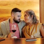 Red Wine, Sexual Desire and Vascular Health: Myth vs Evidence زوجی جوان در حال نوشیدن شراب قرمز در رستورانی شیک، نمادی از باور رایج شراب و سلامت