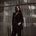 مدیر زن در کت‌وشلوار مشکی کنار نمای شیشه‌ای؛ رفتار گله‌ای و استقلال تصمیم
