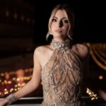 Woman in a crystal-embellished evening gown against night city lights, symbolising what is at stake in high-stakes decisions